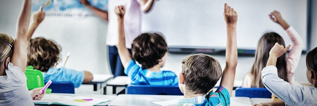 Kids raising hand in classroom